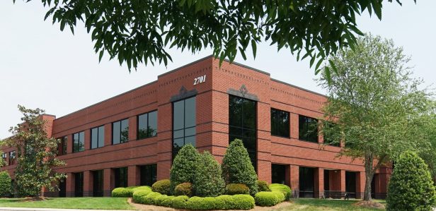 An exterior image of a building within the Aerial Cetner office park located just outside of RDU. Convenient space for office, flex, and life science companies.
