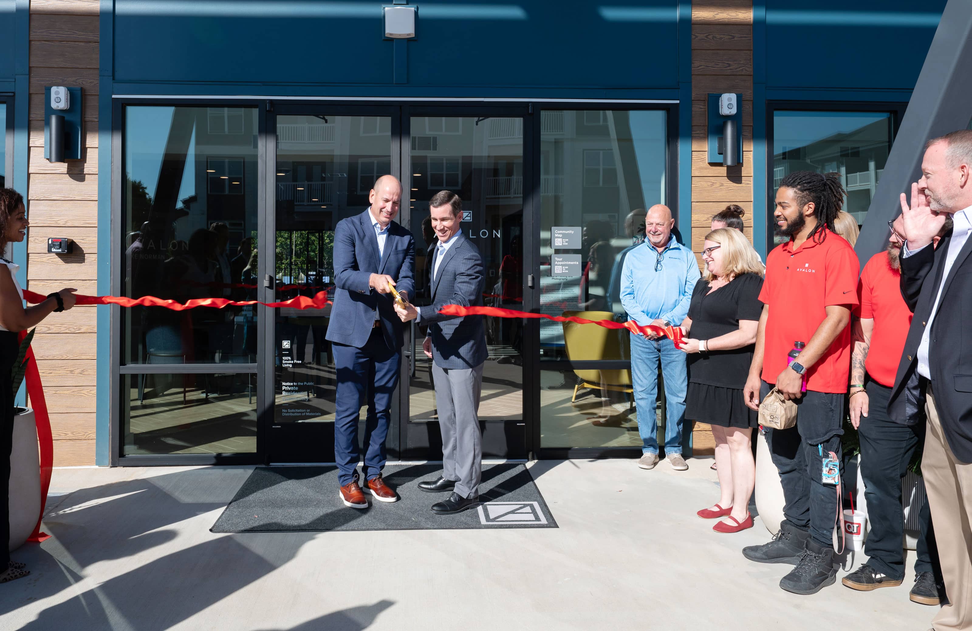 CEO Ribbon cutting in front of new apartment community's entrance